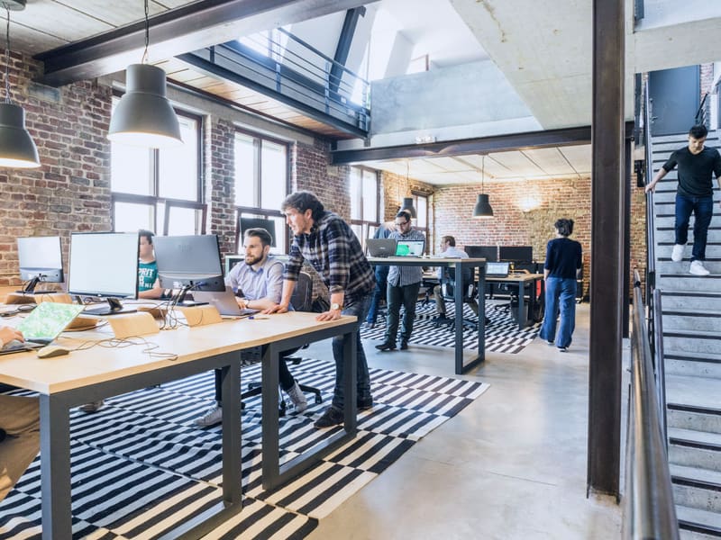 A team working at computers in an open, industrial-style office